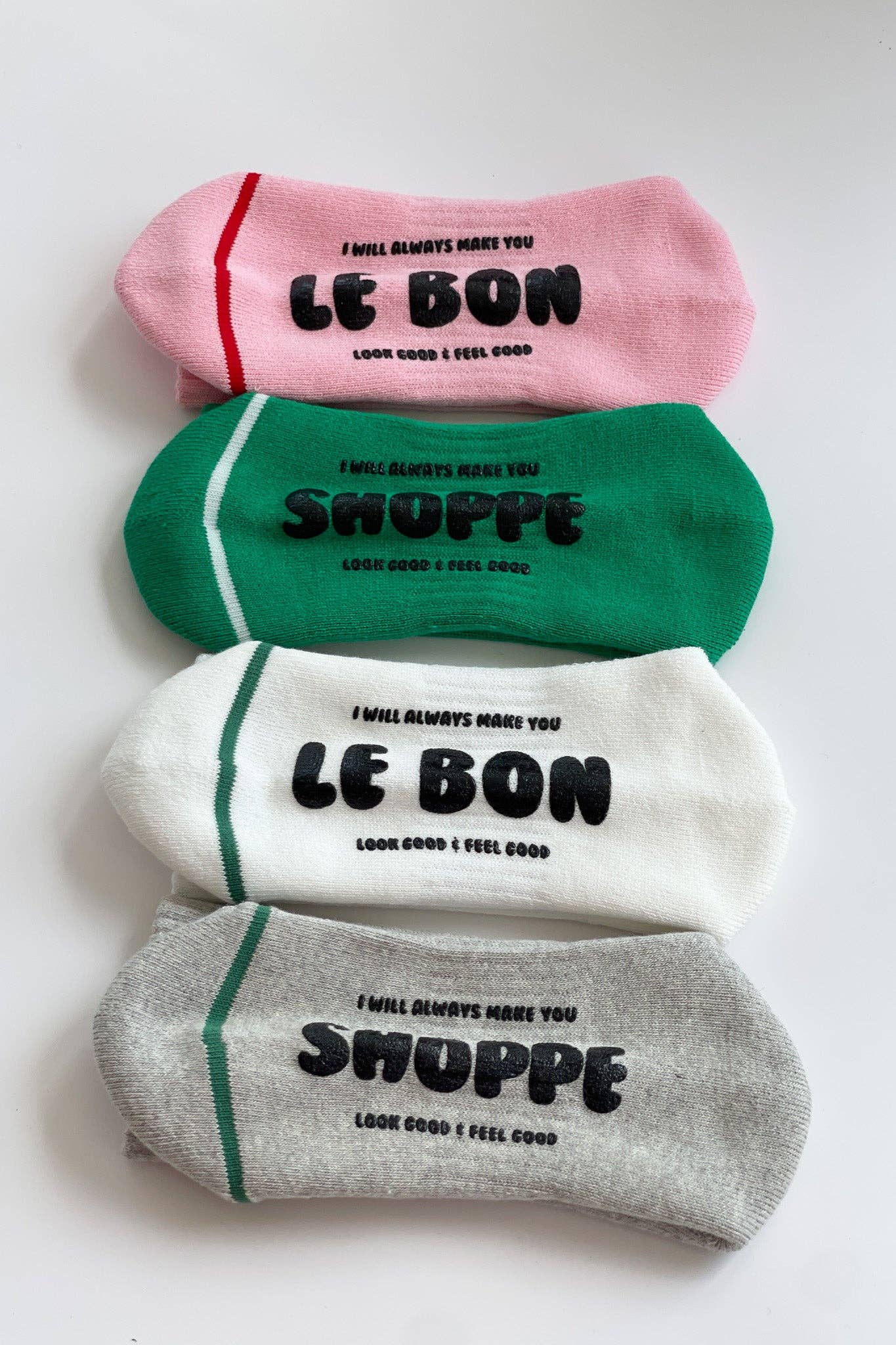 Four pairs of socks in pink, green, white, and gray with text on a white background