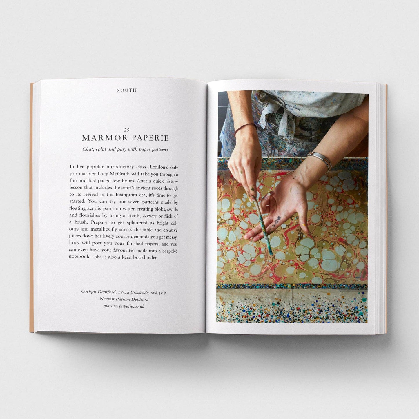 Open book showing a page with text and an image of hands working with paper.