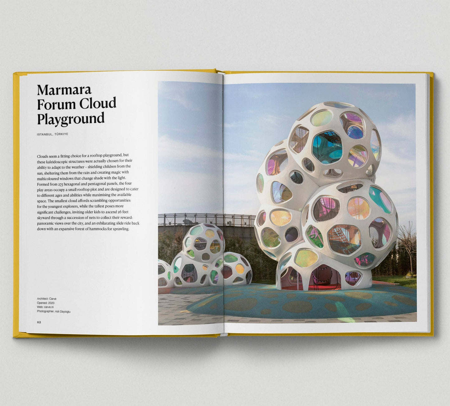 Open book showing a colorful playground structure with text on Marmara Forum Cloud Playground.