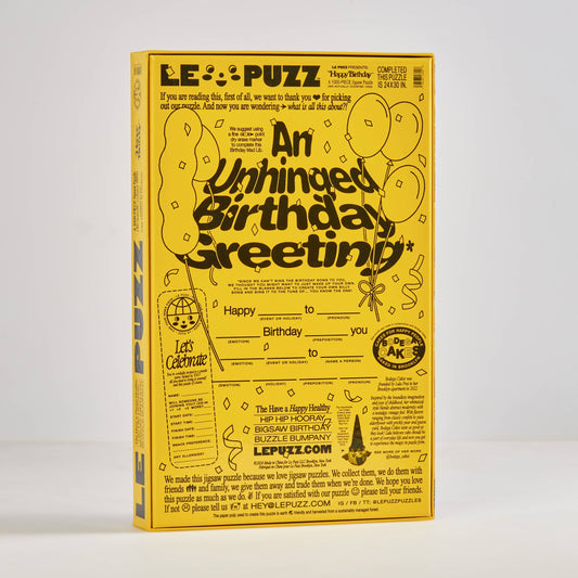 LE PUZZ birthday puzzle packaging with yellow and black design on a white background