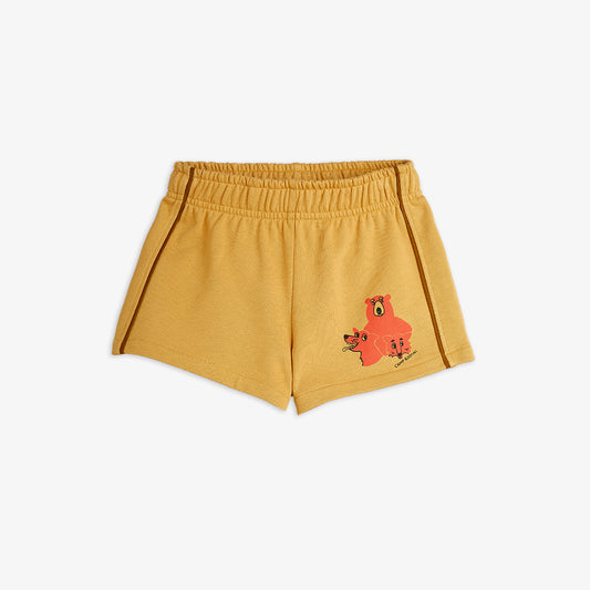 Yellow shorts with a red bear design on a white background