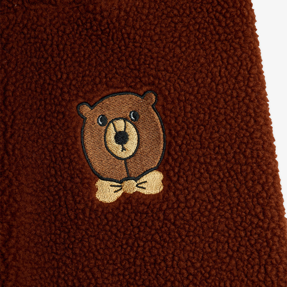 Brown fabric with a teddy bear embroidery on a white background