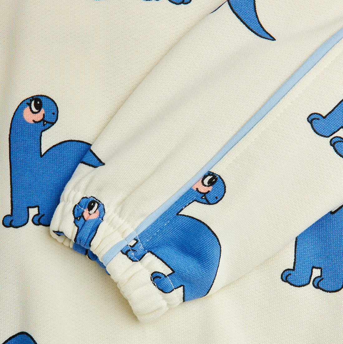 Close-up of a fabric with blue dinosaur prints on a white background