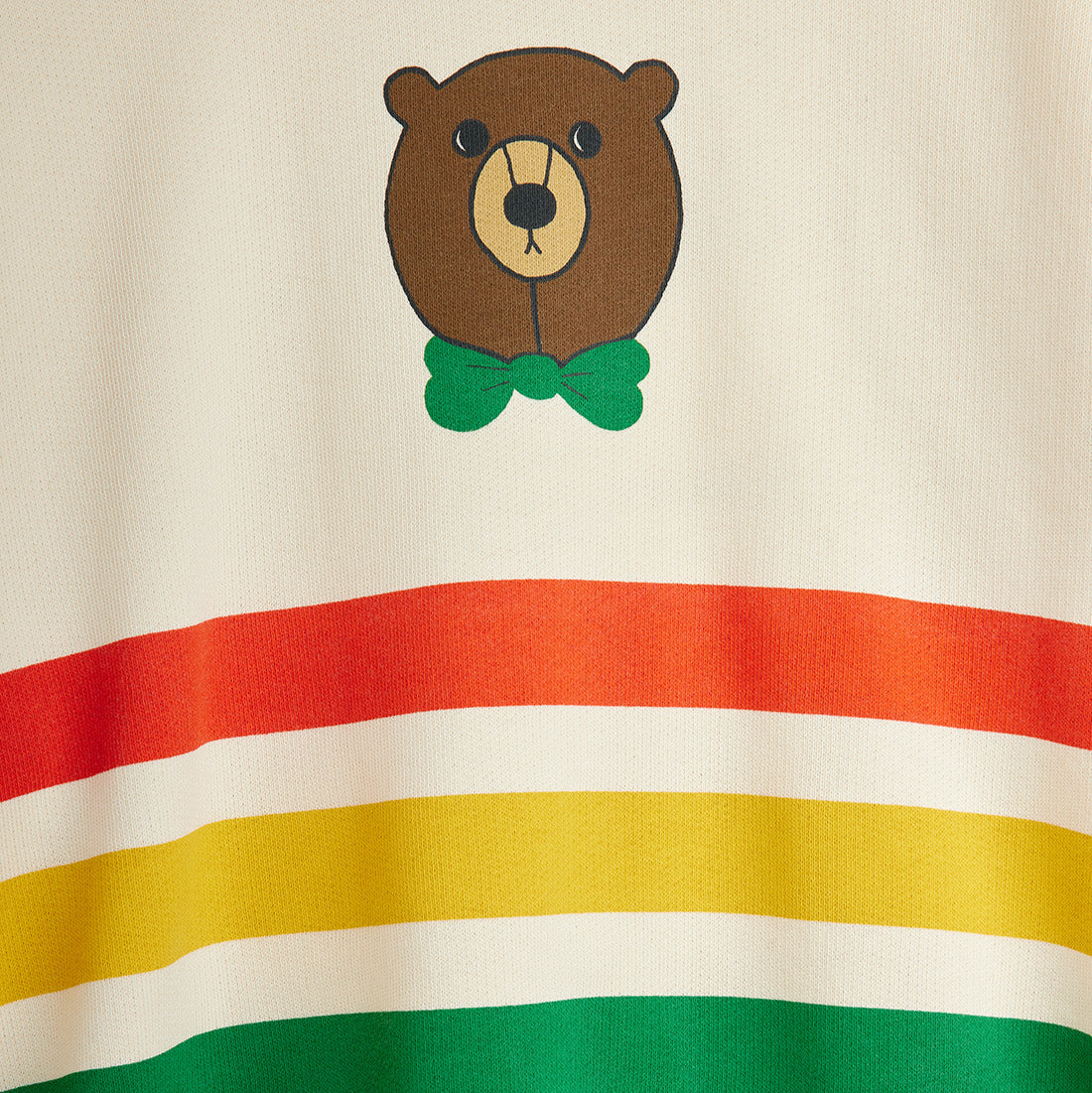 Fabric with a bear face design and colorful stripes on a beige background