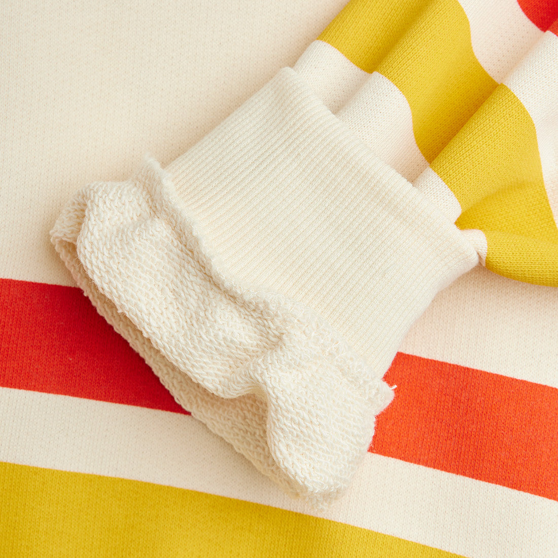 White textured fabric on a colorful striped background
