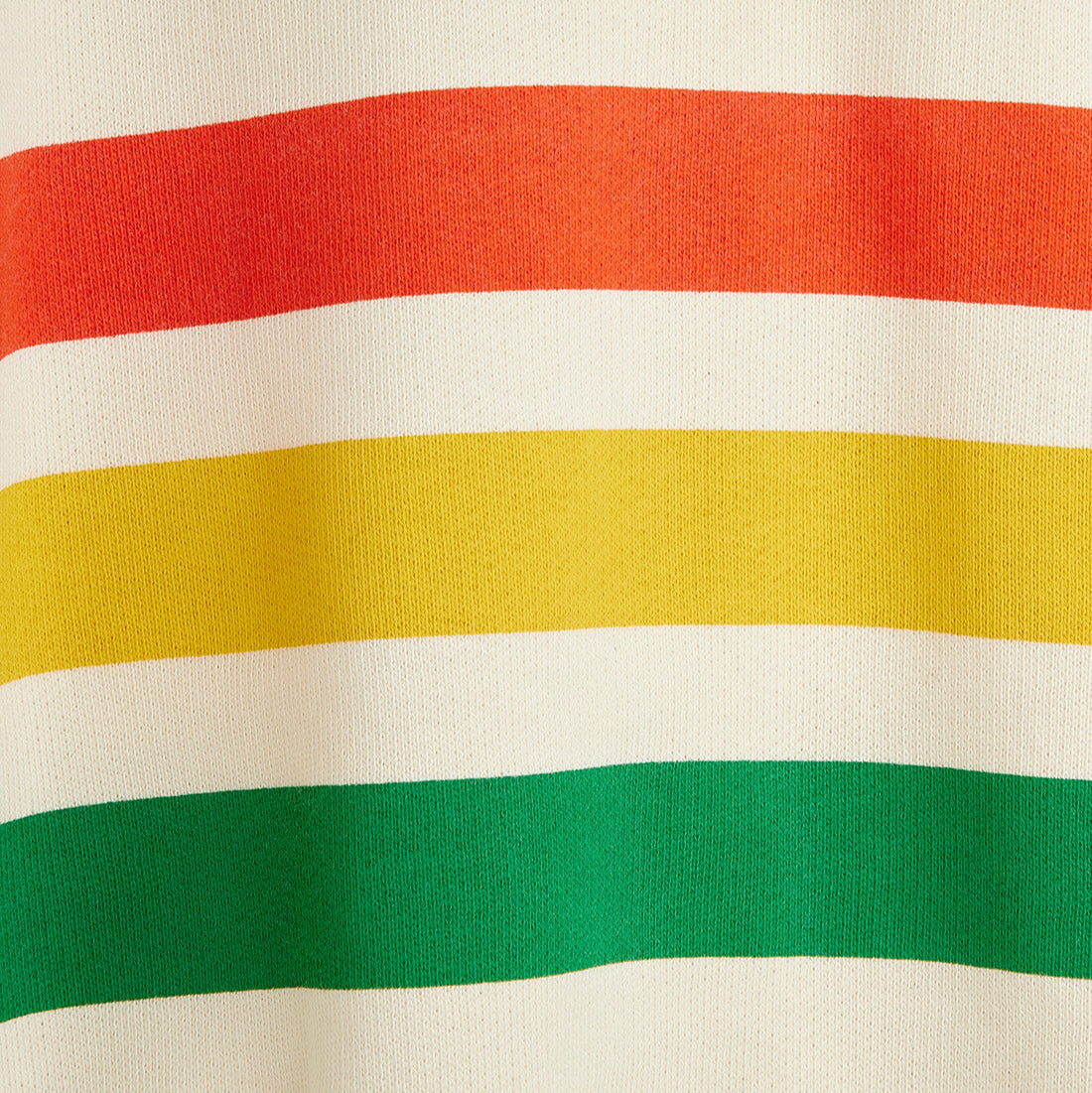 Close-up of fabric with red, yellow, and green stripes on a beige background