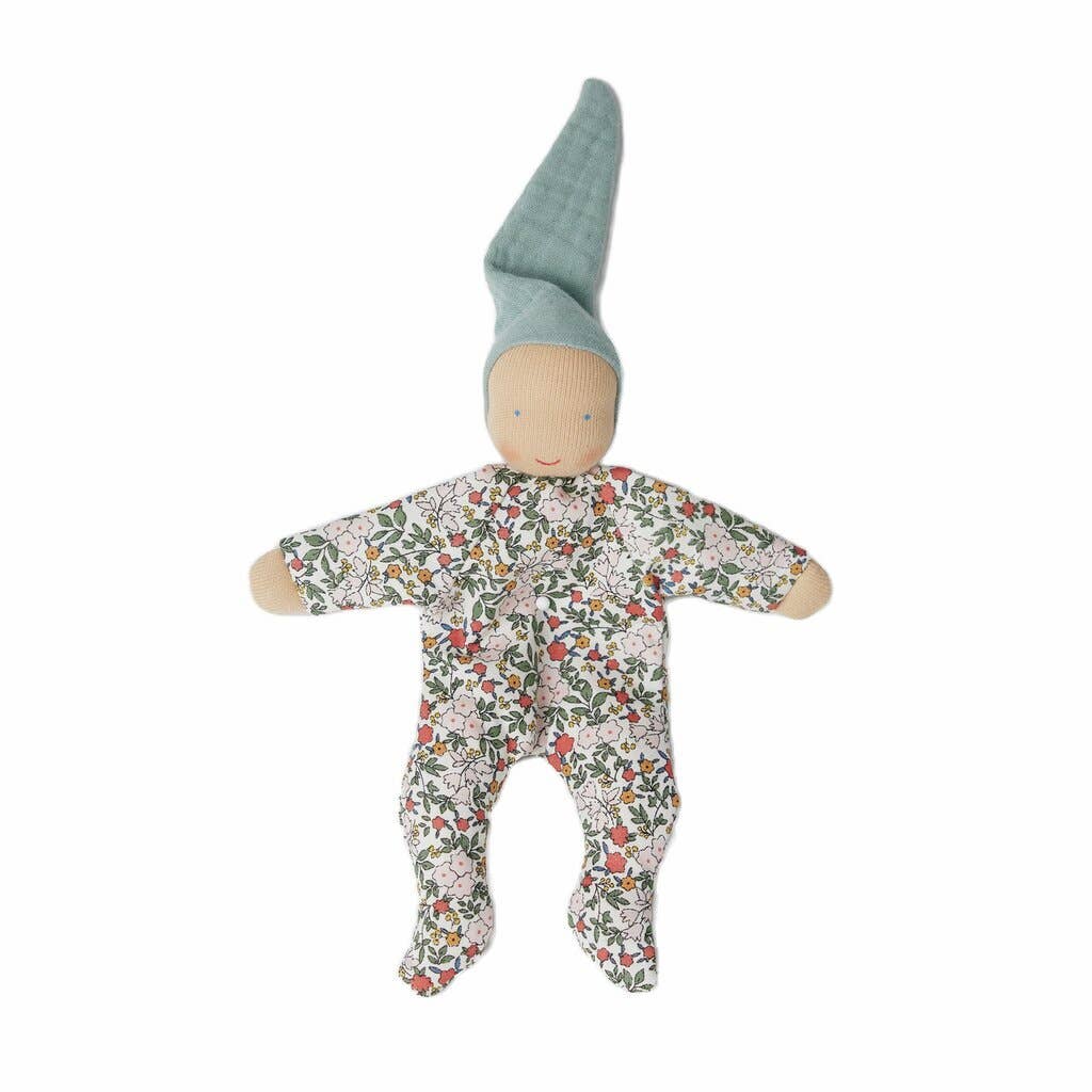 Baby doll with floral onesie and green hat on a white background
