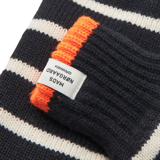Close-up of a striped beanie with an orange and black pattern and a visible brand label.