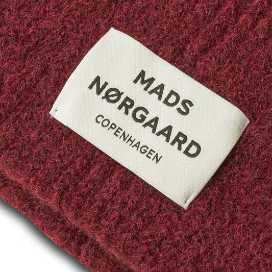 Mads Nérgaard label on a red textured fabric