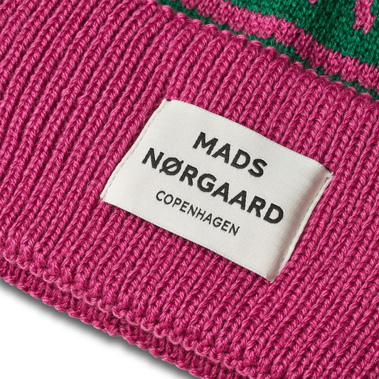 Close-up of a pink knit item with a Mads Nérgaard label on a white background