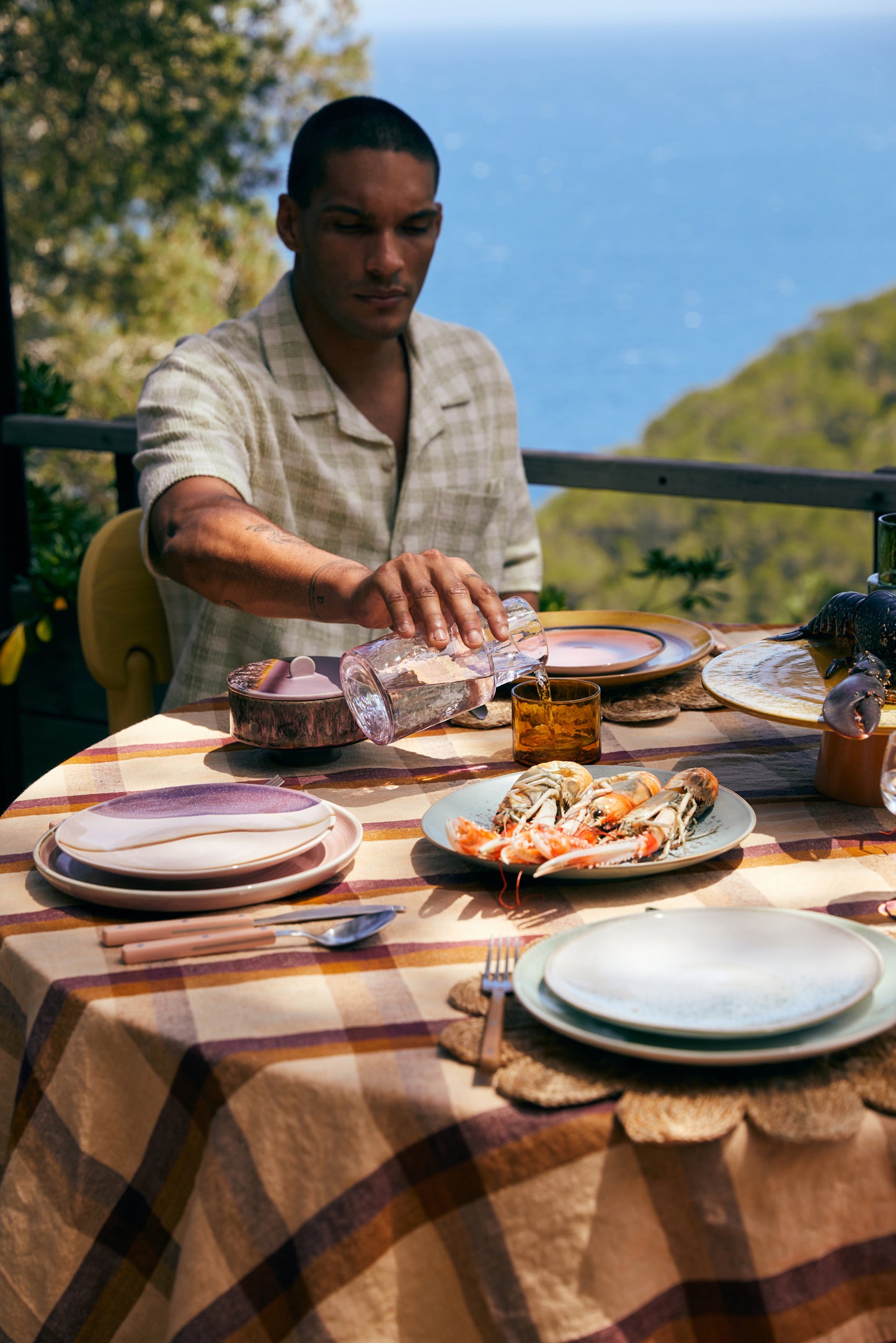 Person setting a table with a scenic background