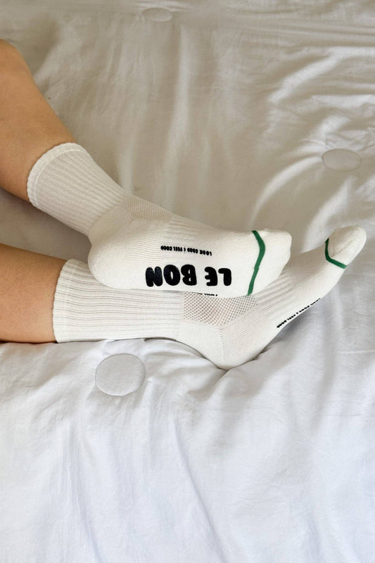 White socks with text on a white bed