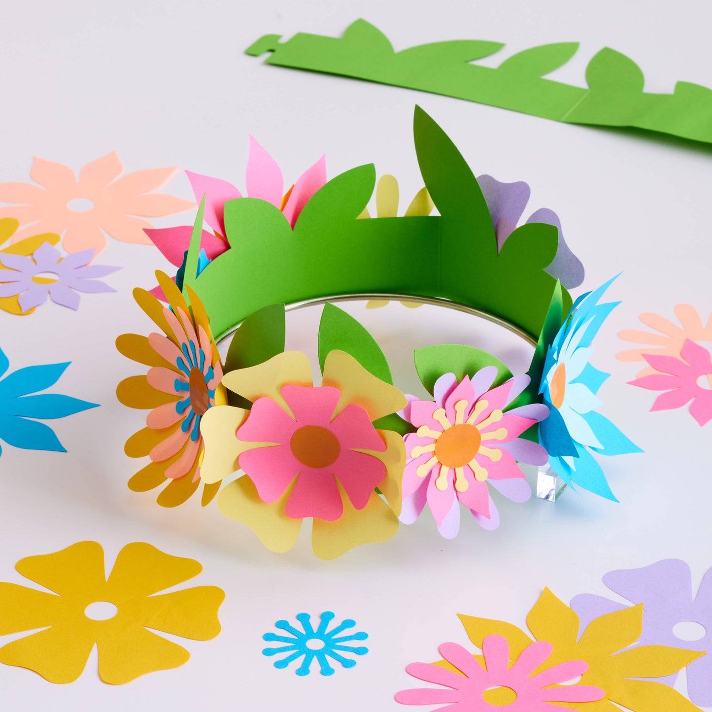 Colorful paper flower headbands on a white background