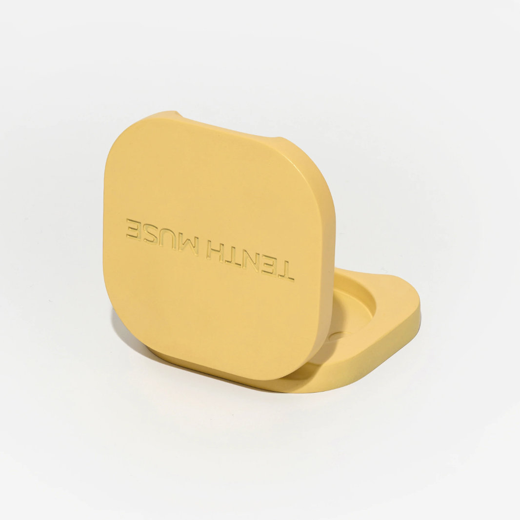 Yellow phone stand with 'TENTH Muse' branding on a white background