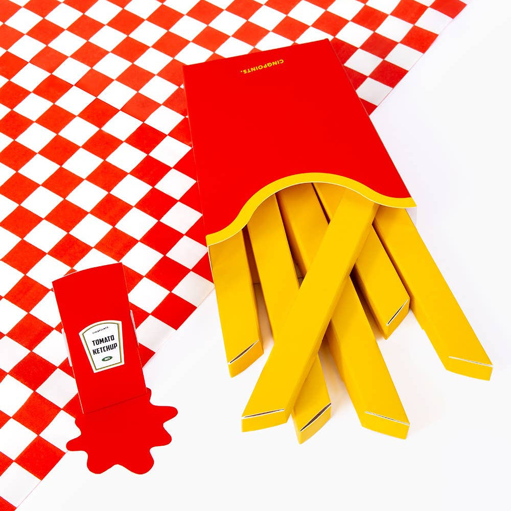Yellow paper cups with a red lid on a red and white checkered tablecloth
