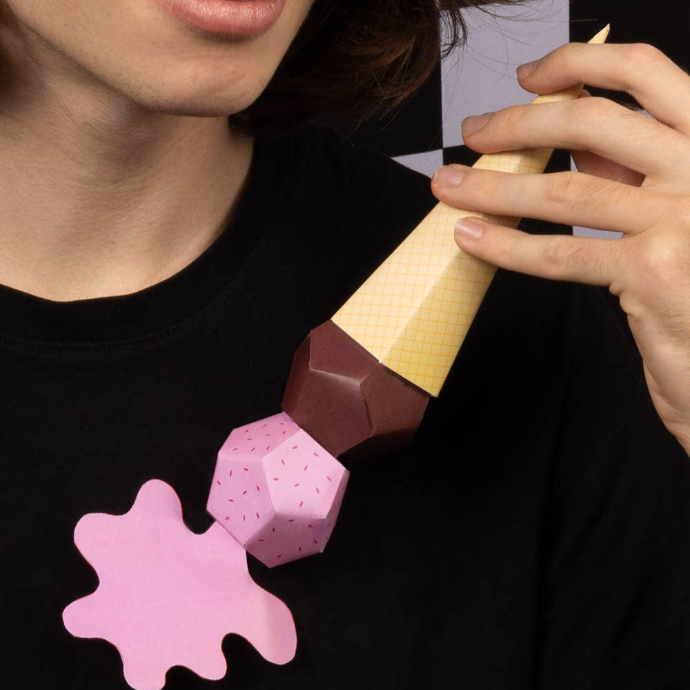 Person wearing a black t-shirt with pink and brown abstract design, holding a pink and brown object.