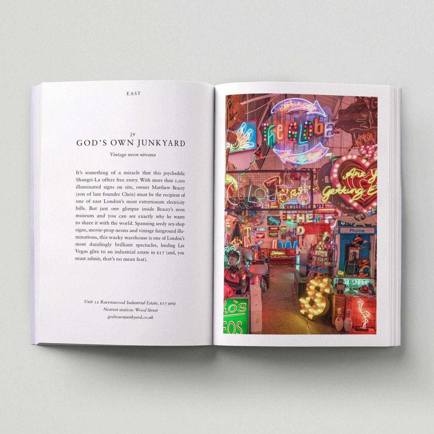 Open book with a page showing text and another with a colorful neon sign street scene.