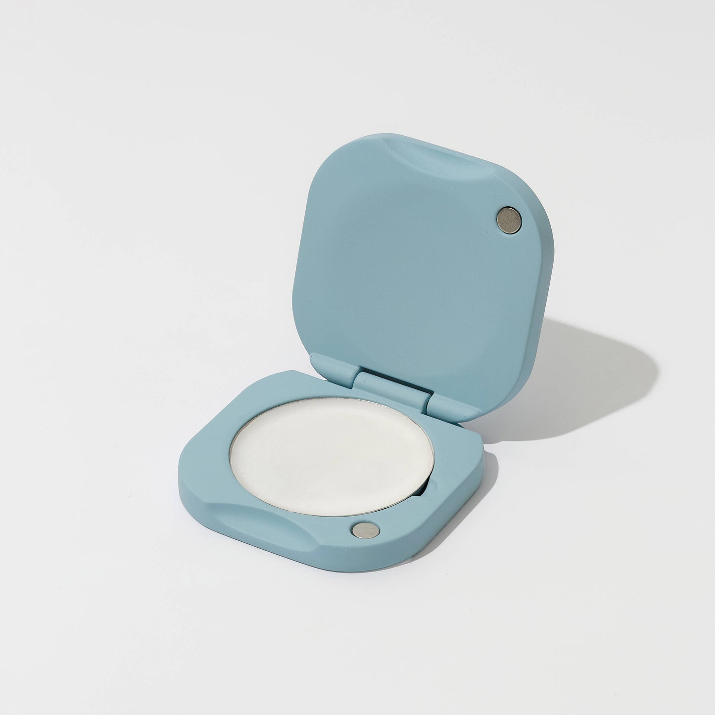 Compact powder in a light blue case on a white background