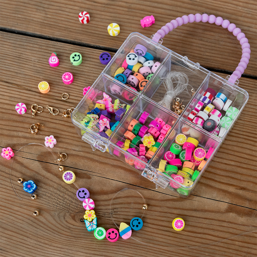 Colorful beaded accessories in a clear storage box on a wooden surface