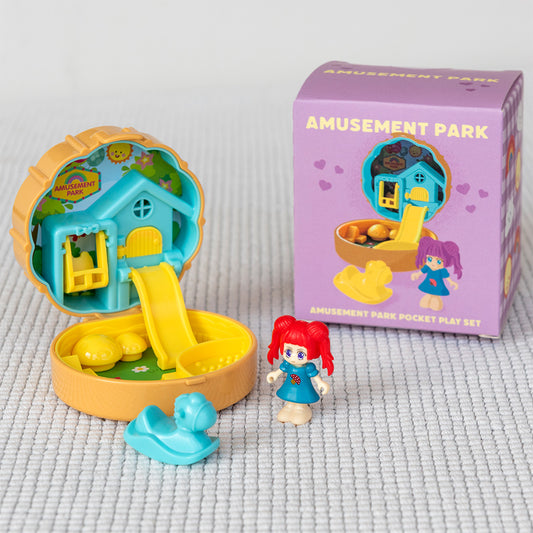 Toy set with a pocket-sized amusement park playset and a figurine on a textured surface.