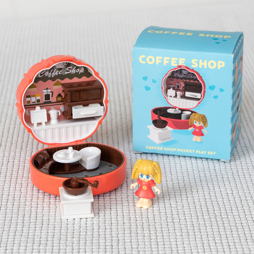 Coffee shop pocket play set with toy and packaging on a textured surface