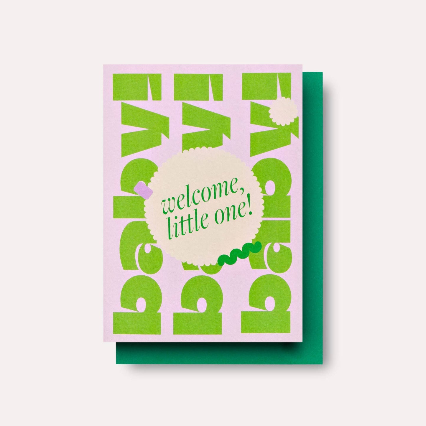 A greeting card with a green envelope, featuring text 'welcome, little one!' on a pink background, decorated with a pattern of green shapes.