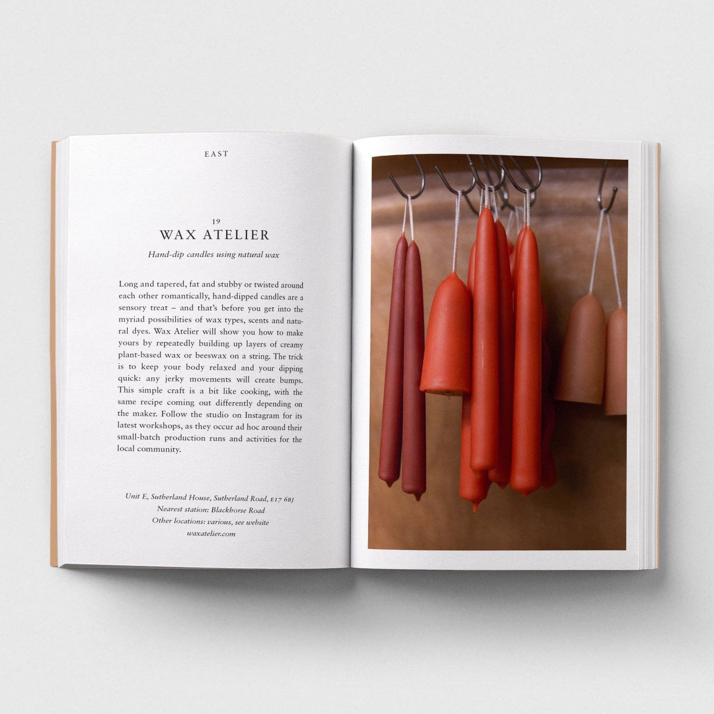 Open book with text on one page and a photograph of red candles on the other, on a white background.