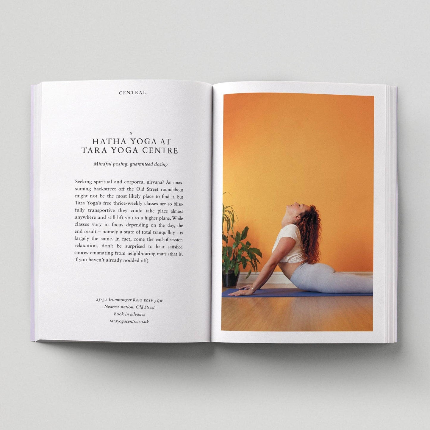 Open book showing a yoga pose on one page and text on the other, against a light gray background.