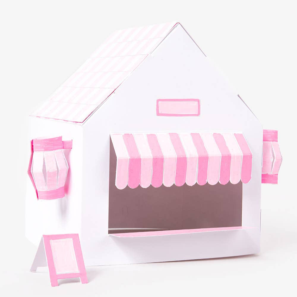 Small house-shaped display case with pink and white striped awning on a white background