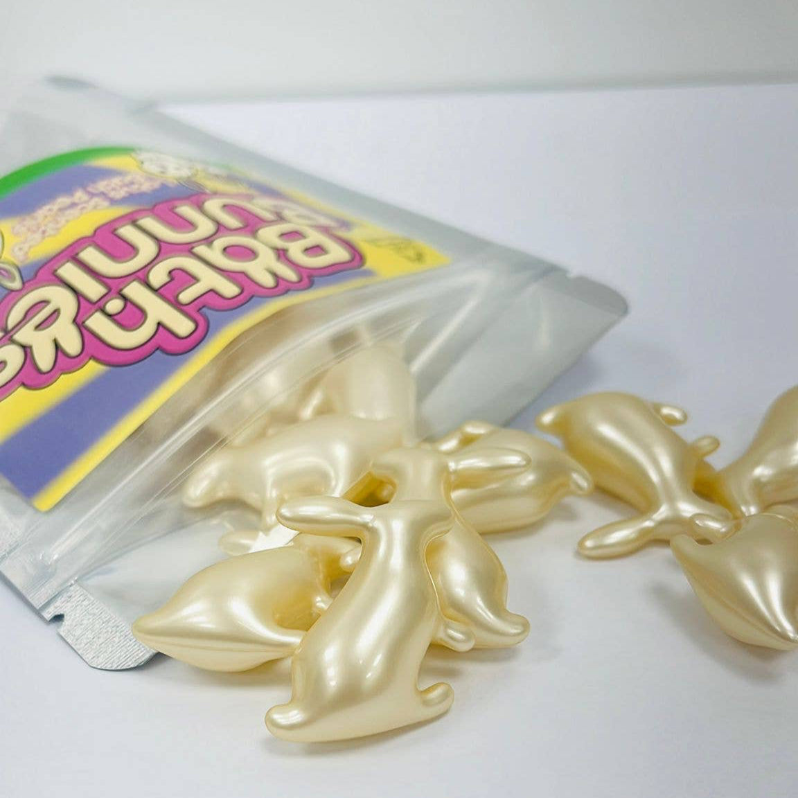 Packaged snacks with white bunny shaped bath pearls on a white background