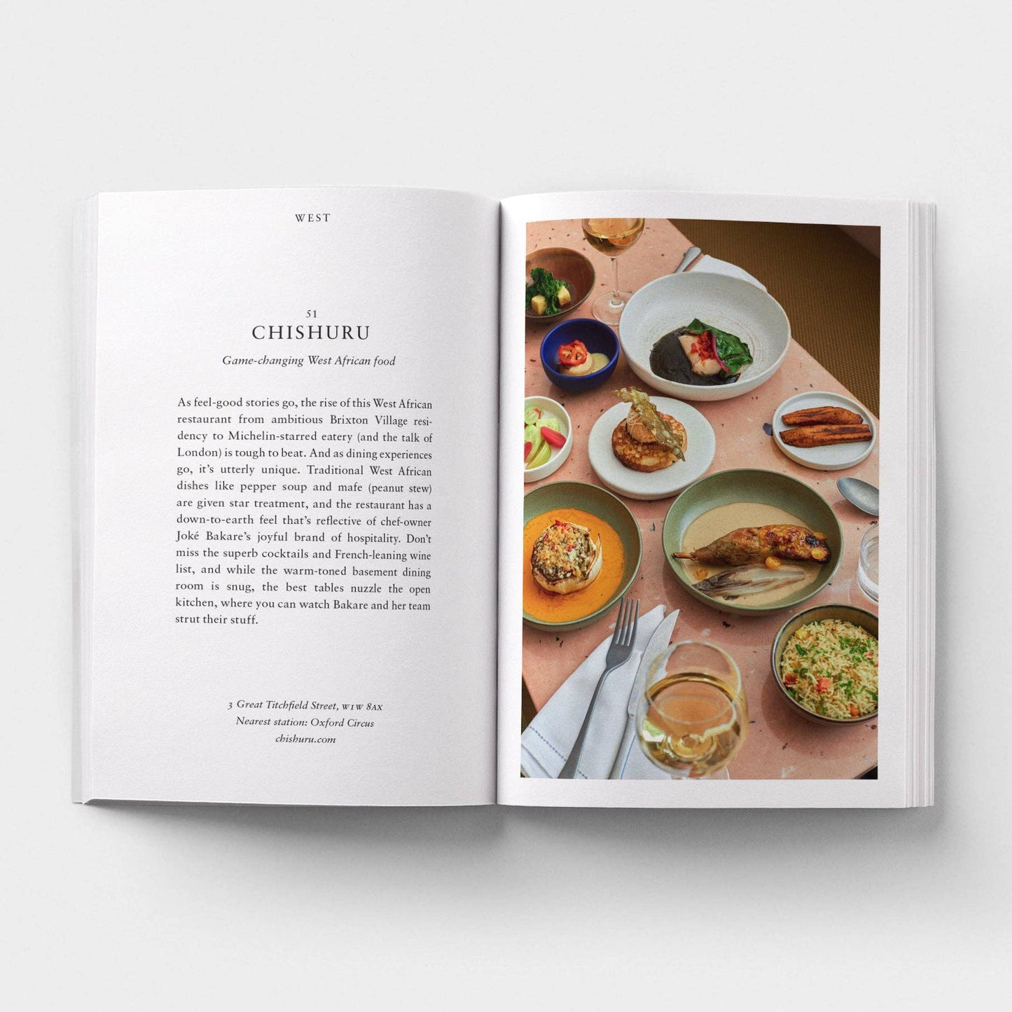 Open book showing a page with text and a photograph of a dining table with food.