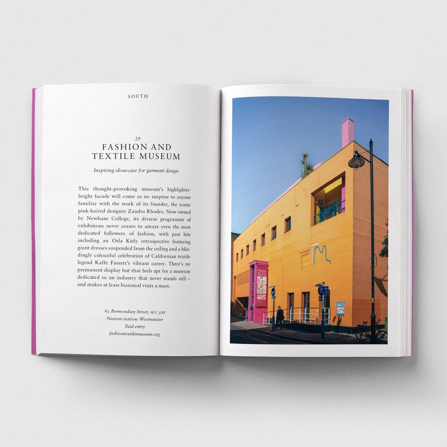 Open book showing a page with text and an image of a colorful building.