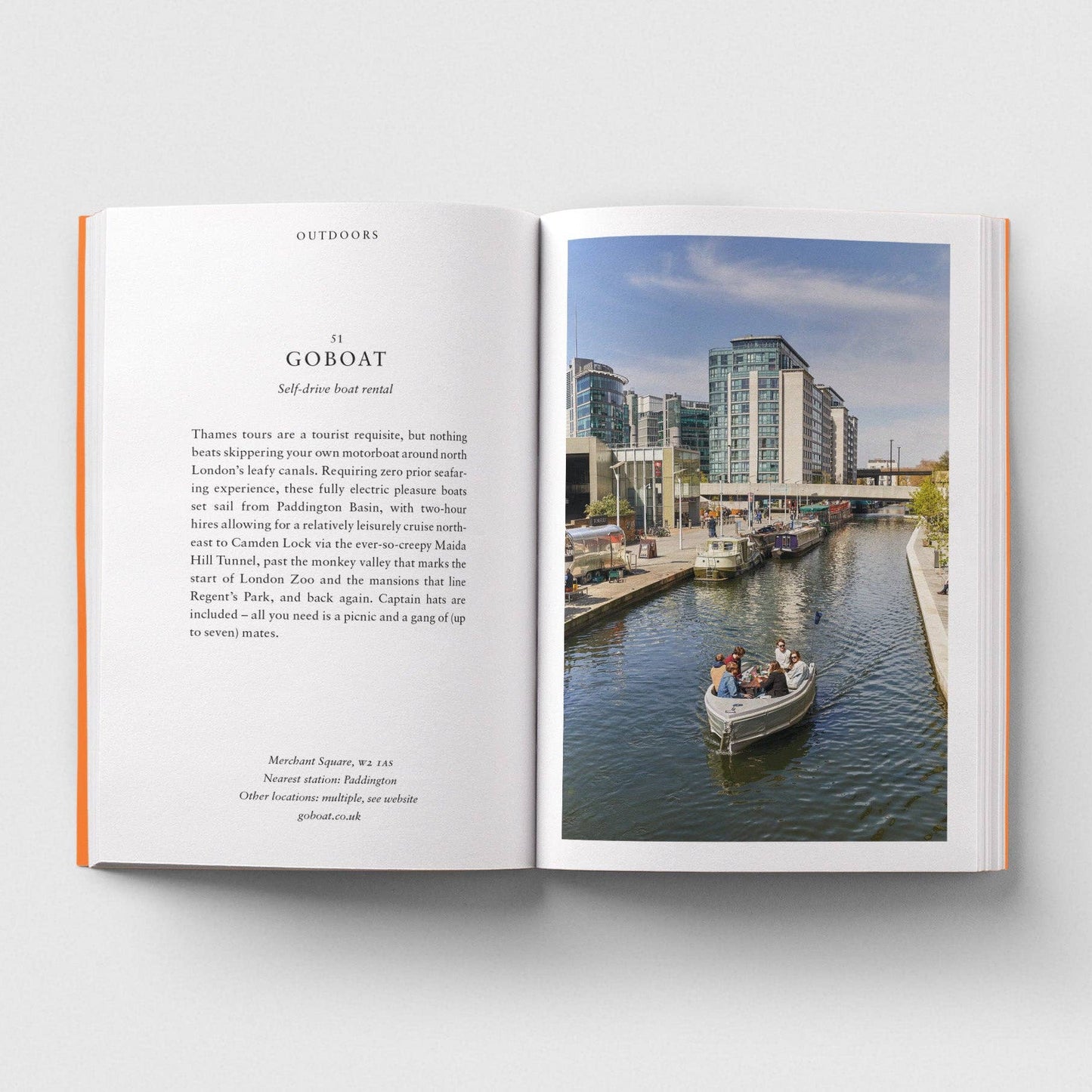 Open book with text on the left and a photograph of a canal scene with a boat on the right.