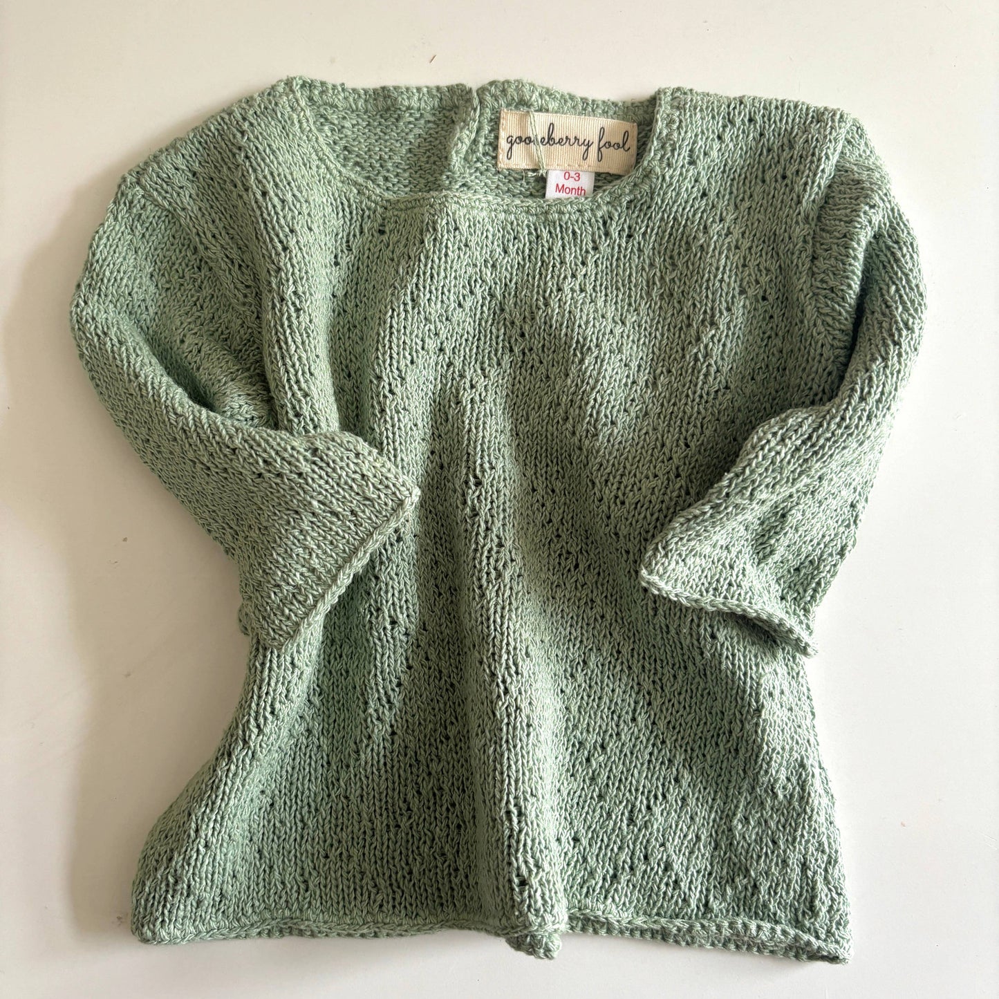 Green knitted sweater on a white background