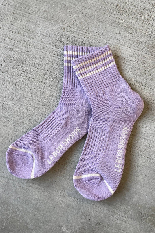 A pair of purple socks with white and gray stripes at the opening, branded with 'Le Bon Shoppe' on the foot area.