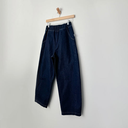 Relaxed wide-leg jeans with an elasticated waist and contrast stitching, displayed on a wooden hanger against a neutral background.