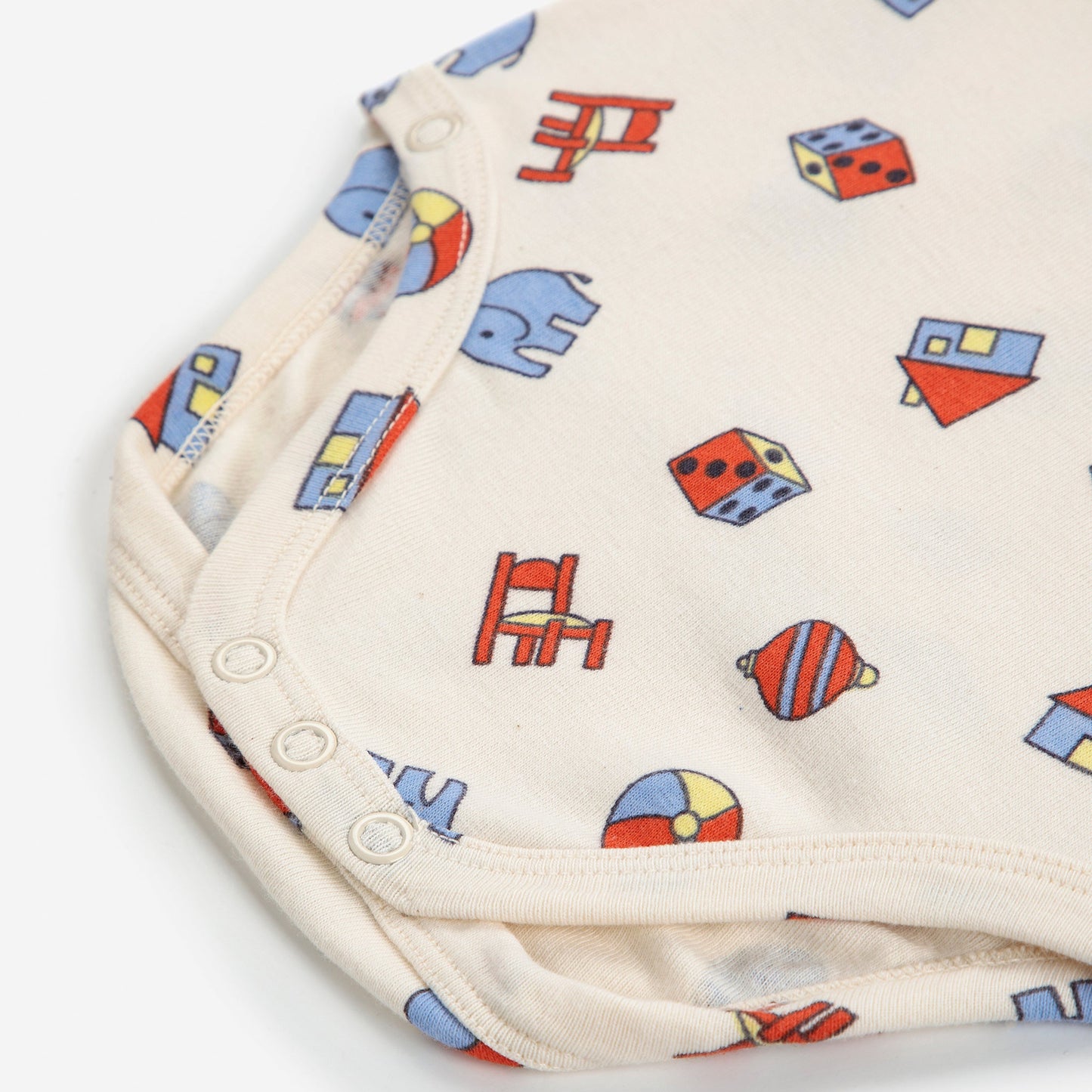 Folded fabric with colorful toy patterns on a white background