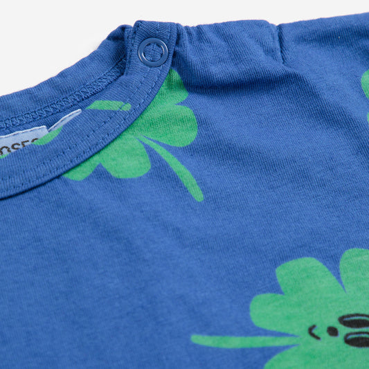 Blue baby t-shirt with green clover patterns on a white background