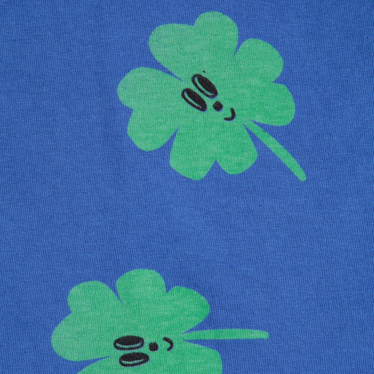 Two green four-leaf clover designs on a blue background