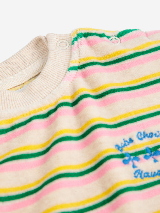 Close-up of a sweater with colorful stripes and a brand logo on a white background
