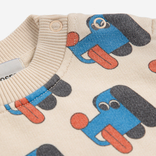 Children's sweater with blue and orange dog pattern on a beige background