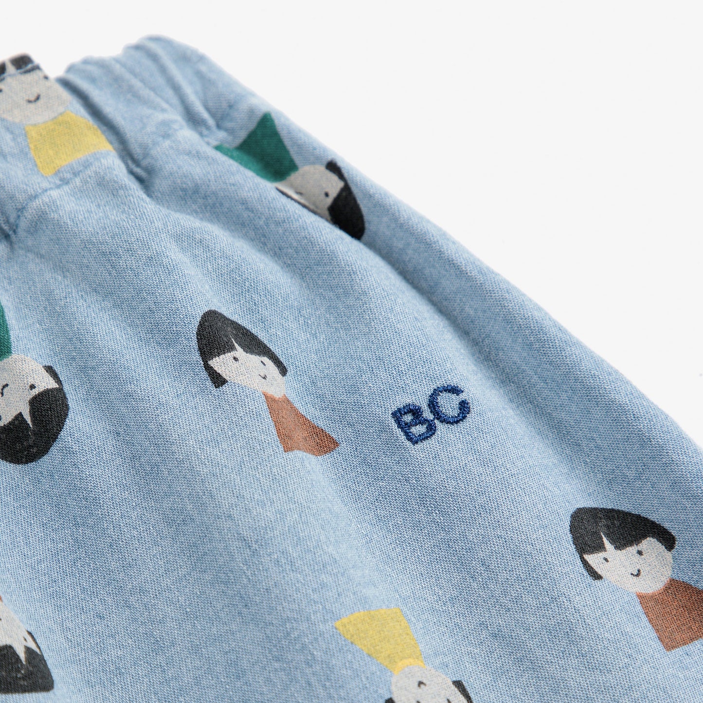 Light blue fabric with cartoon character patterns and 'BC' initials on a white background