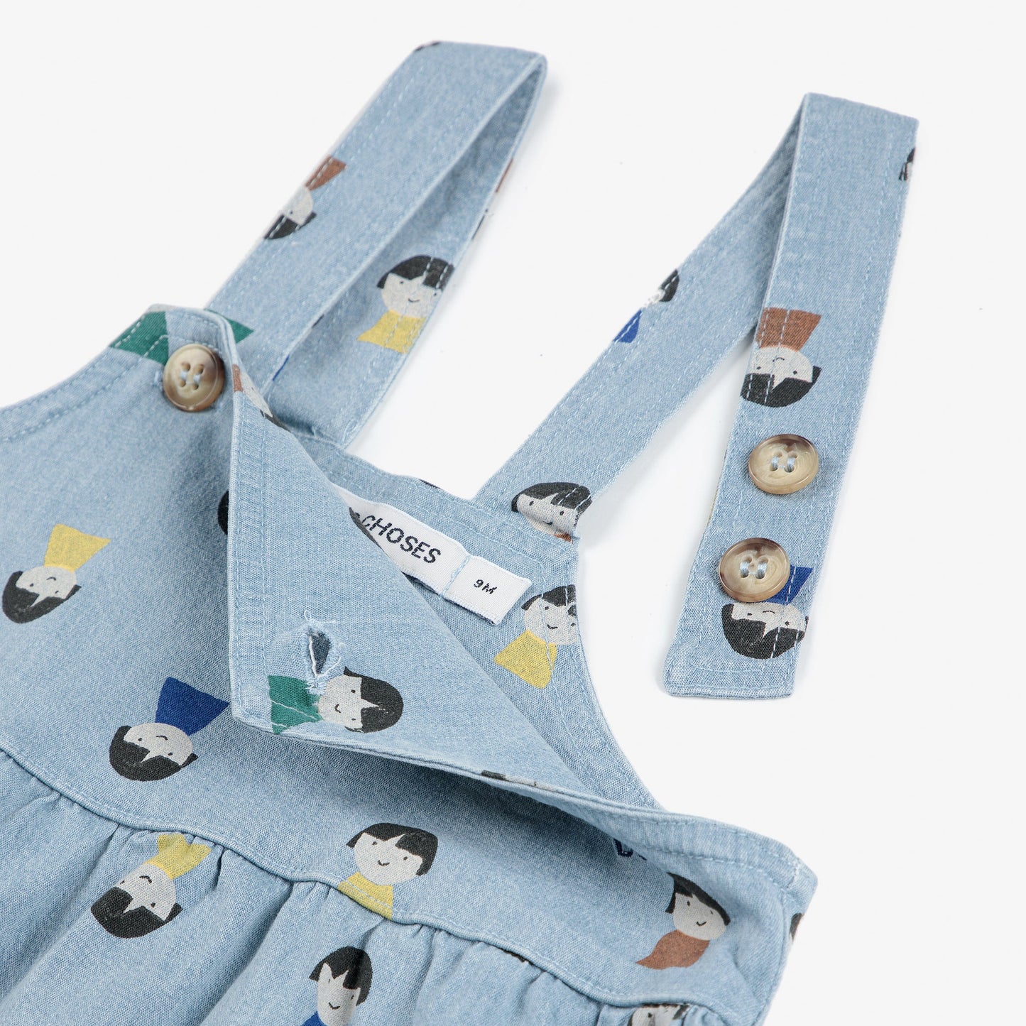 Light blue denim dungarees with character print and straps on a white background