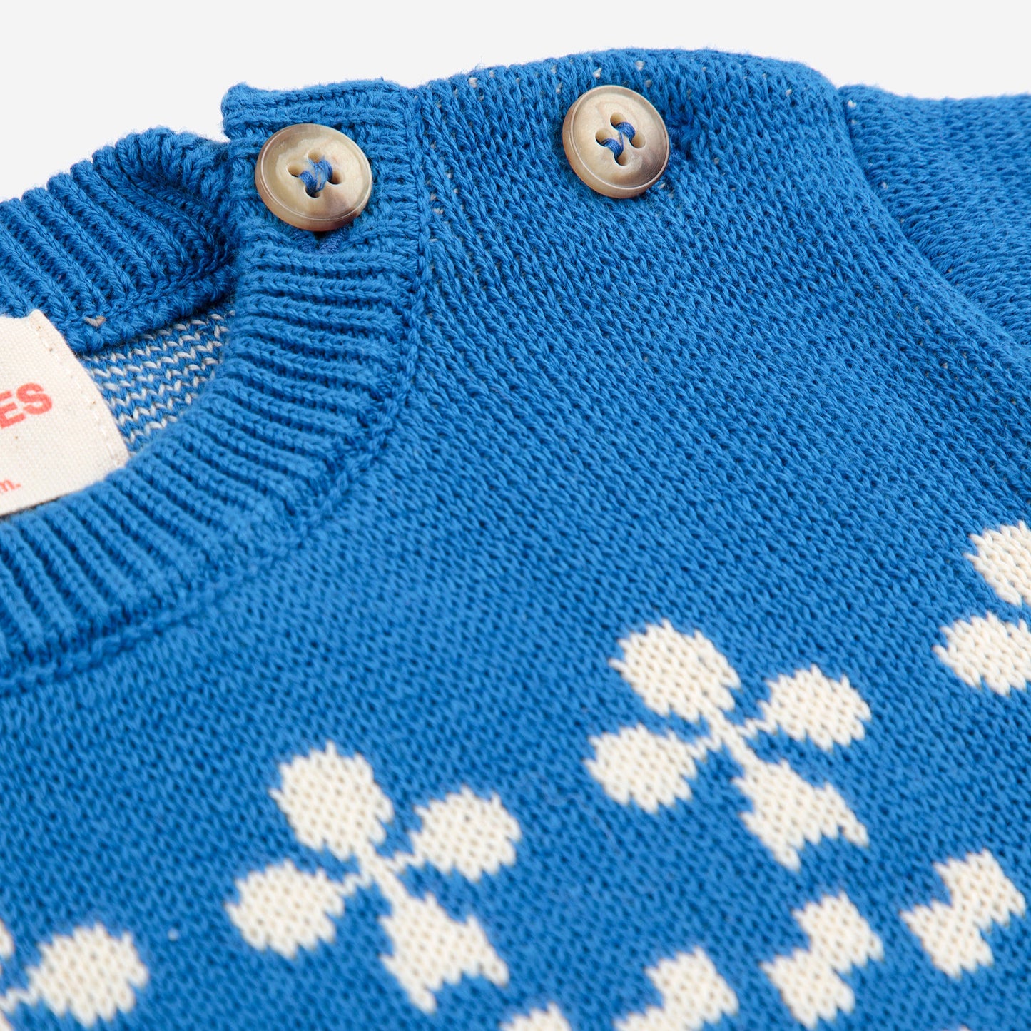 Blue knitted sweater with white snowflake pattern on a white background