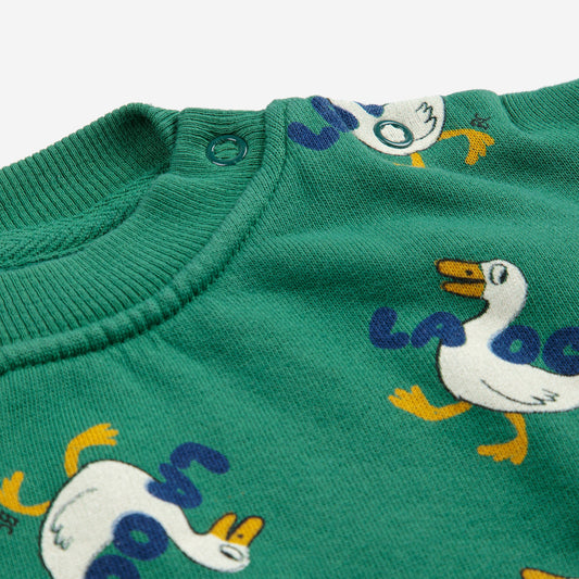 Green sweater with cartoon duck pattern on a white background