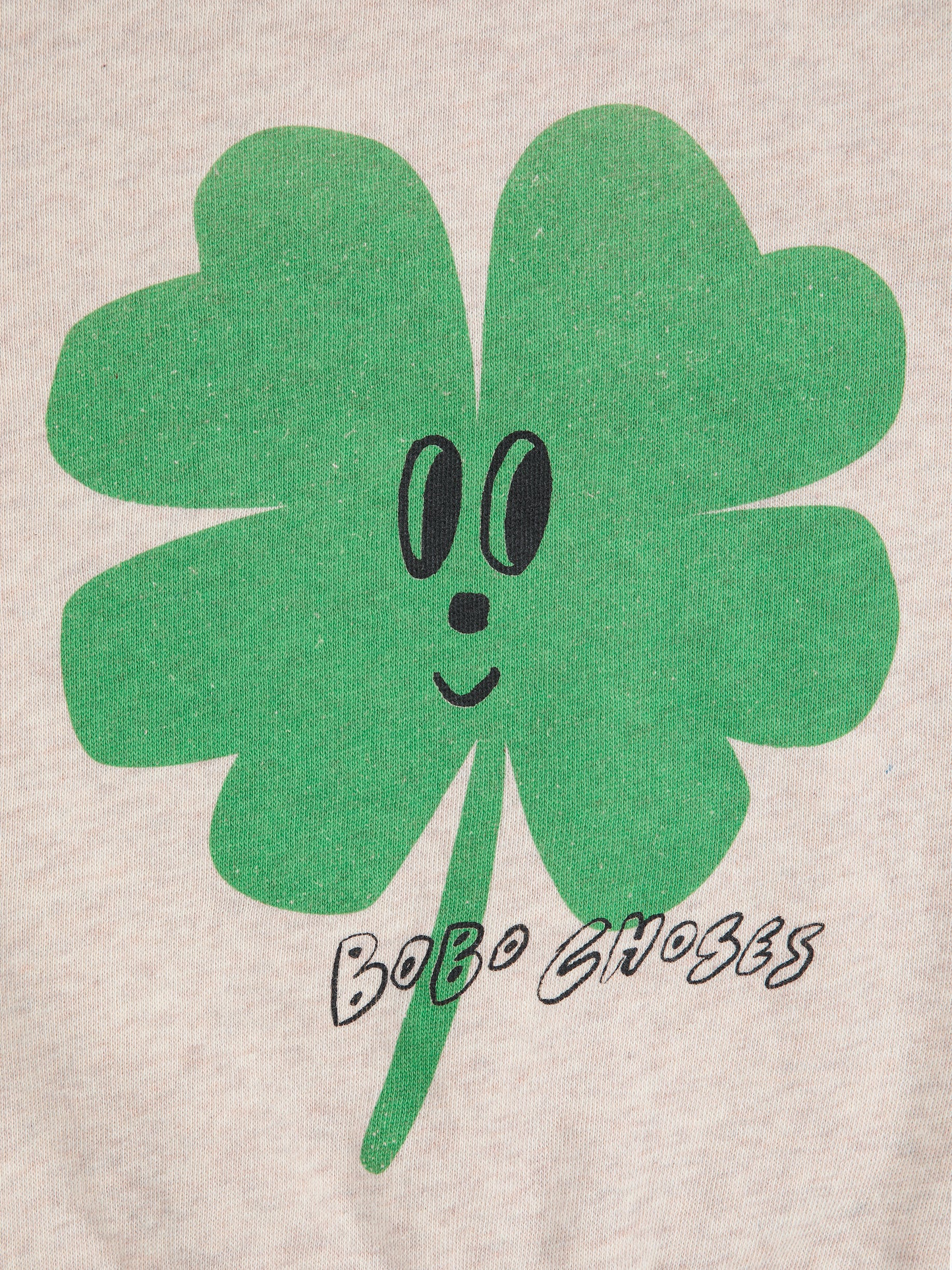 Green four-leaf clover with a face and 'Bobo Choses' text on a beige background