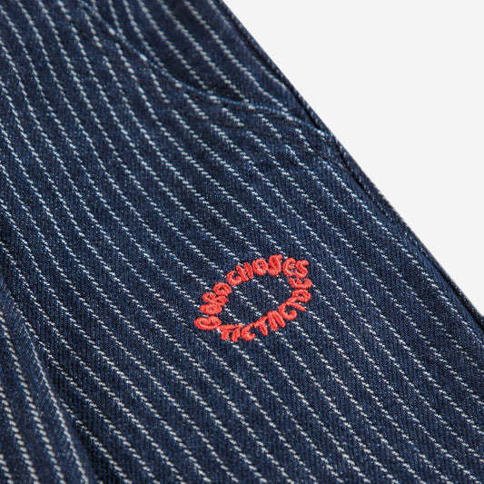 Close-up of a blue pinstripe fabric with a red embroidered logo on a white background