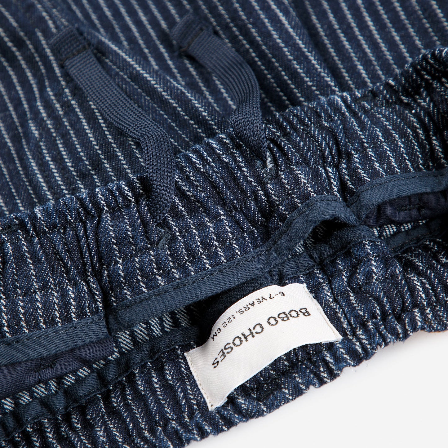Close-up of a blue denim fabric with a brand label on a white background