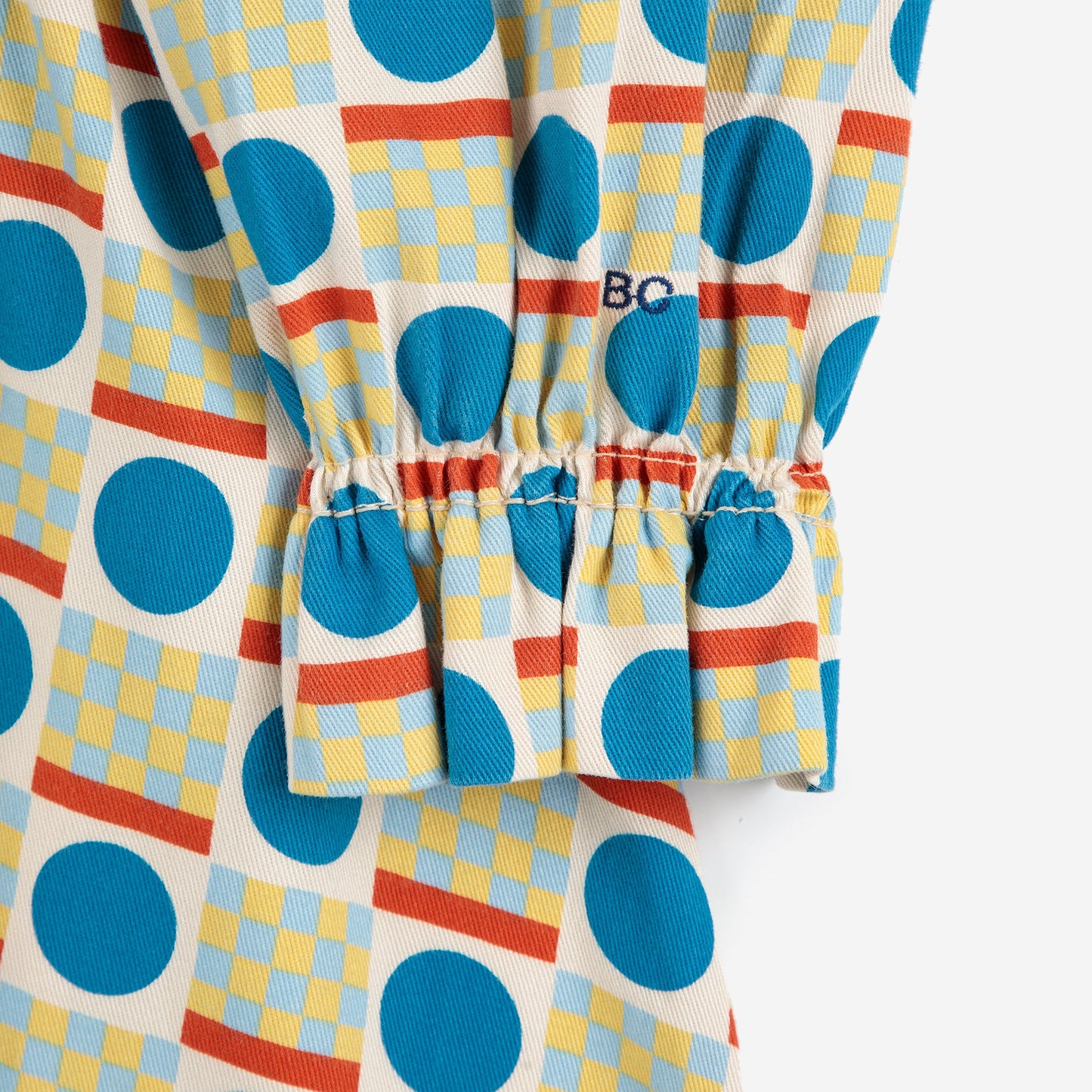 Colorful patterned pants with blue circles and red and yellow stripes on a white background