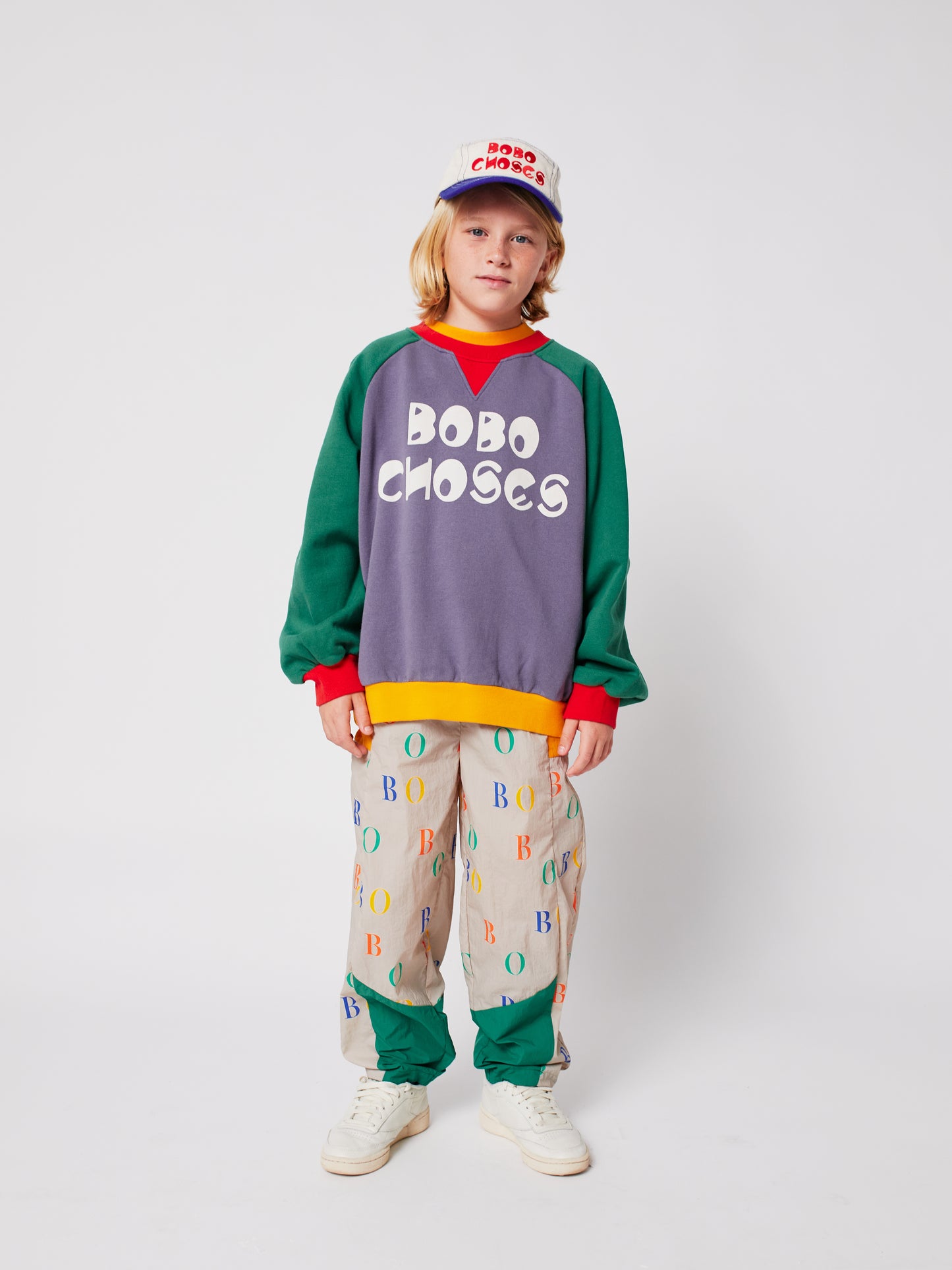 Child wearing a colorful outfit with 'Bobo Choses' branding on a white background